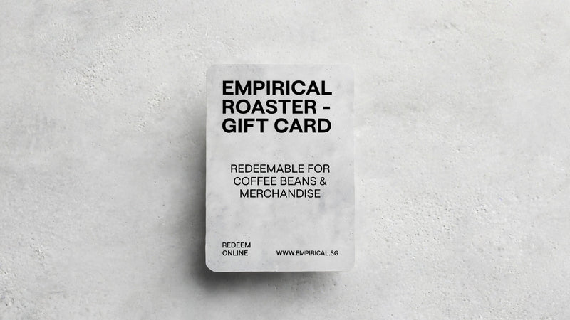 Empirical Roaster gift card standing upright on a concrete surface